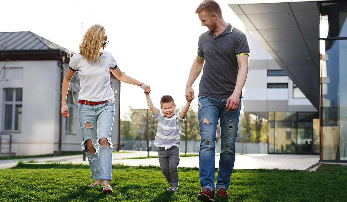 Mom and dad whirl their son and have fun walking outside